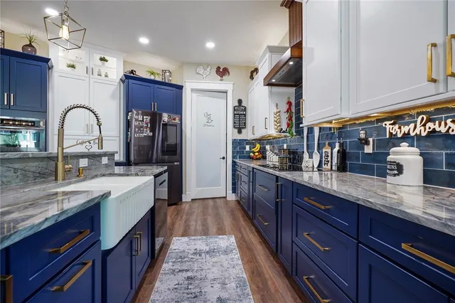 a kitchen with stainless steel appliances granite countertop a refrigerator and a sink