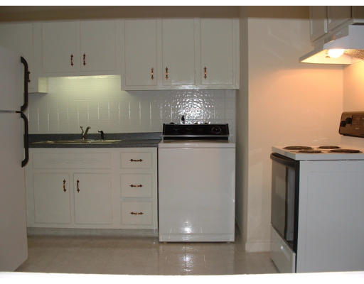 140 Groton Street Springfield, MA 01129 - Photo 3 of 8 a kitchen with granite countertop white cabinets and white appliances