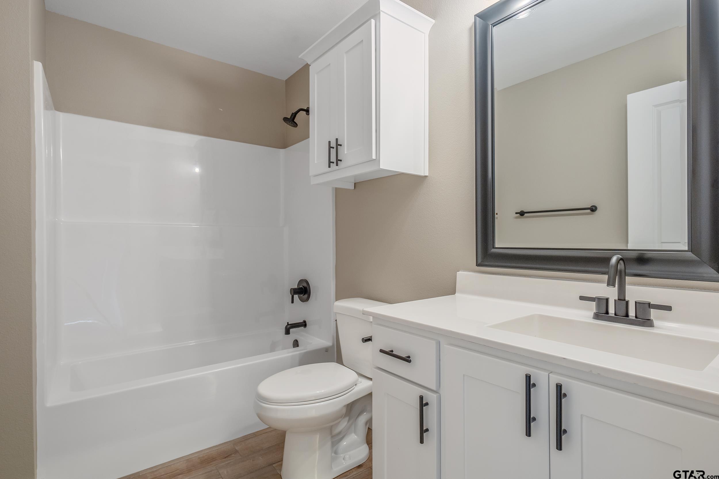 16218 Crossing Circle Lindale, TX 75771 - Photo 17 of 24 a bathroom with a sink a toilet and shower