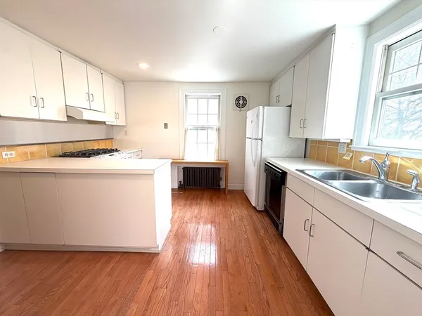 a kitchen with granite countertop a sink a counter top space and cabinets