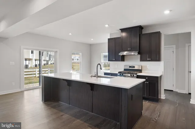 a kitchen with stainless steel appliances kitchen island granite countertop a sink and cabinets