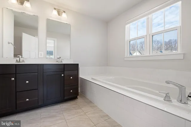 a spacious bathroom with a tub sink and mirror