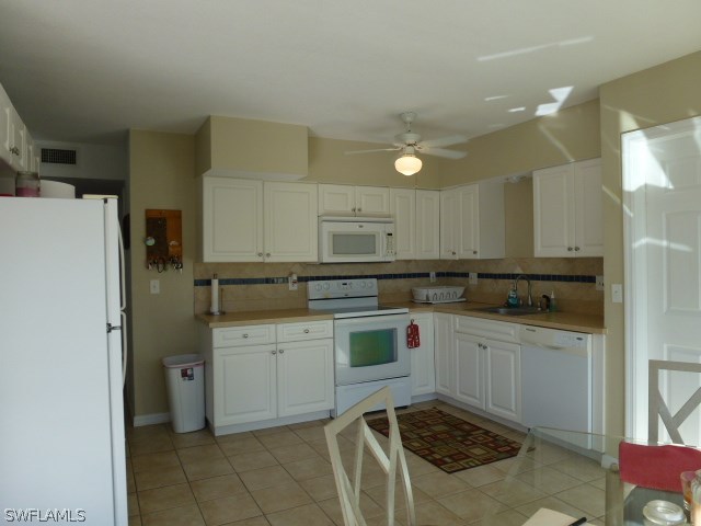 1450 Mandel Road Fort Myers, FL 33919 - Photo 12 of 18 a kitchen with a sink a stove a refrigerator and cabinets