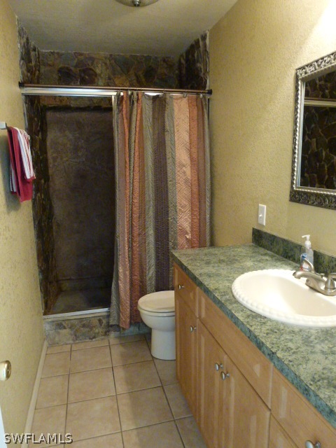 1450 Mandel Road Fort Myers, FL 33919 - Photo 6 of 18 a bathroom with a granite countertop sink a toilet and shower