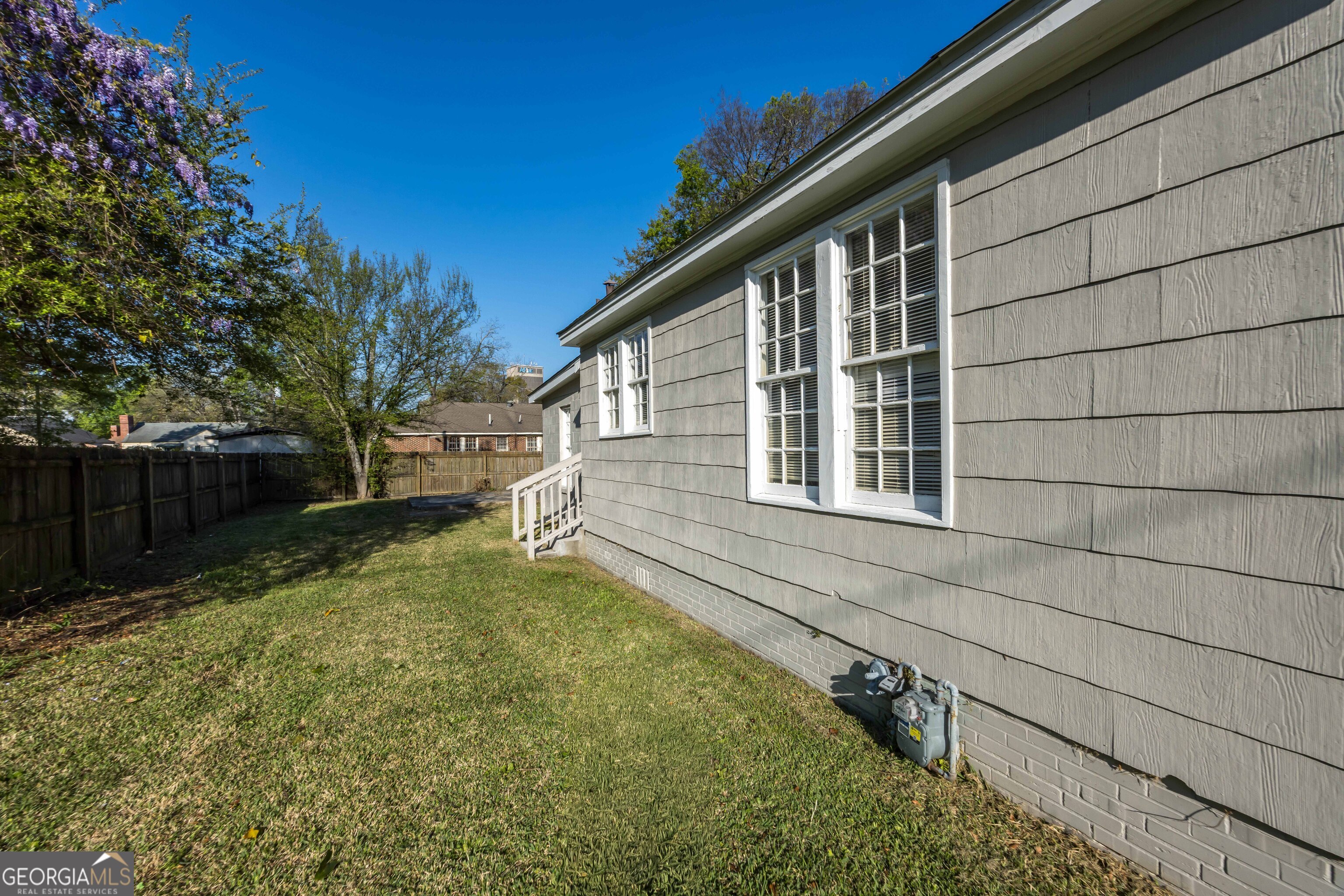 1103 Bryan Avenue Columbus, GA 31906 - Photo 17 of 24 a backyard of a house with large trees and a wooden fence