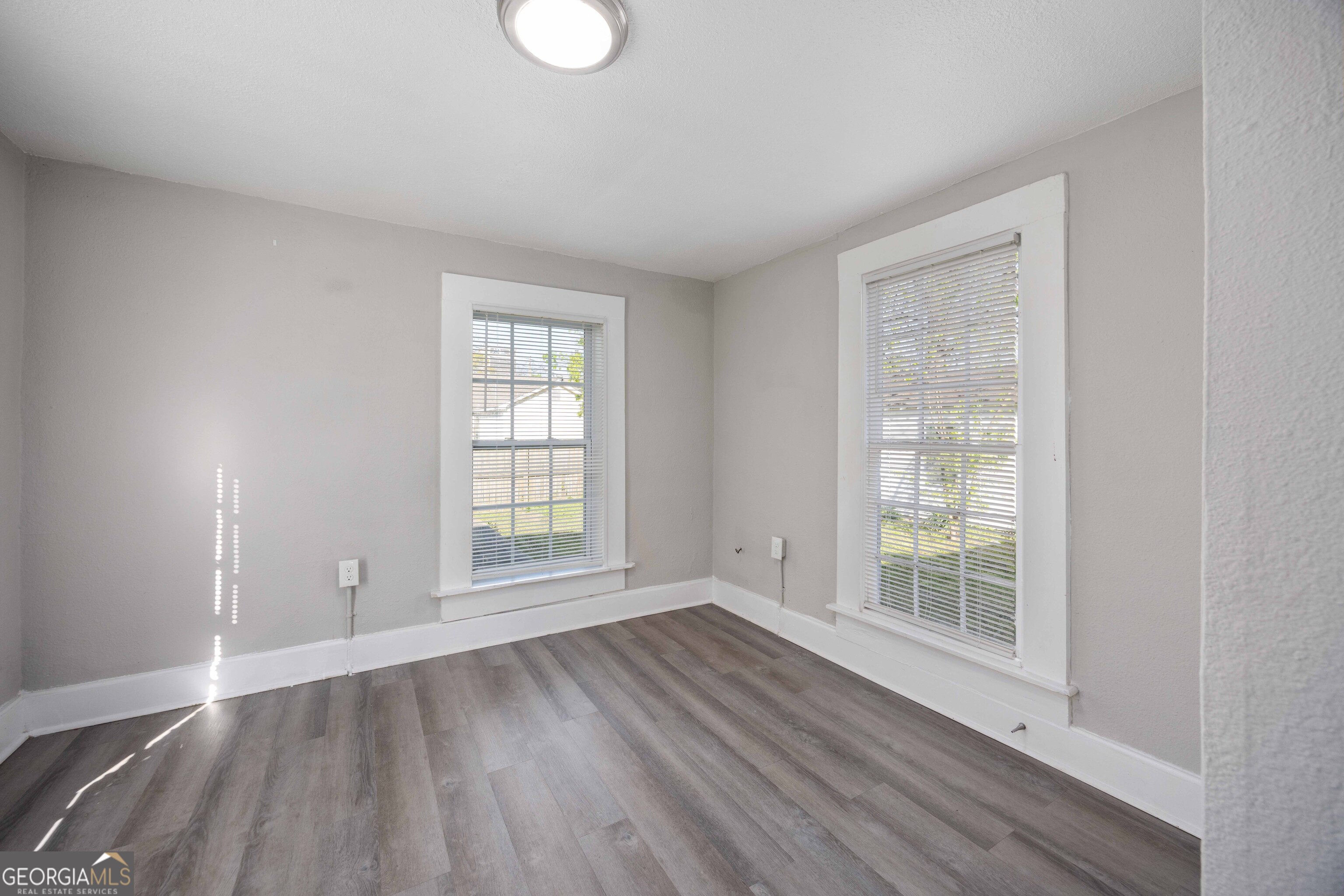 1103 Bryan Avenue Columbus, GA 31906 - Photo 10 of 24 an empty room with wooden floor and windows