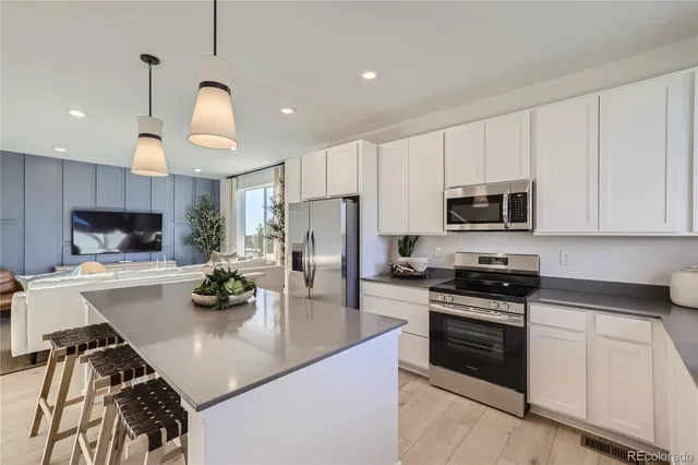 a kitchen with a sink a stove and chairs