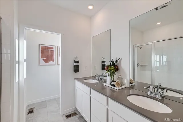 a bathroom with a granite countertop sink a mirror and a shower