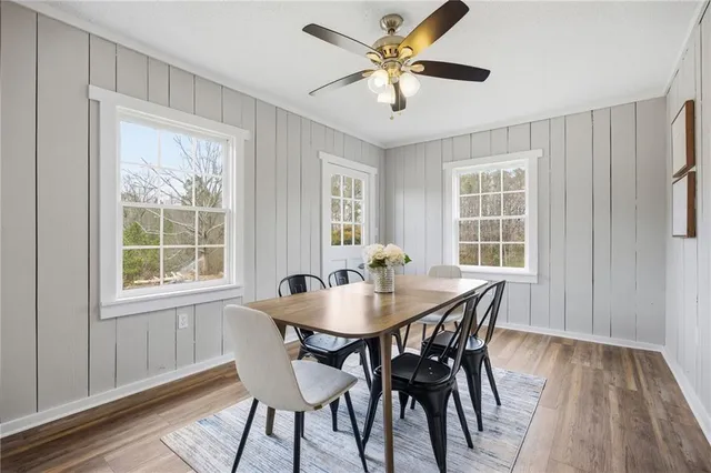 a kitchen with stainless steel appliances granite countertop a dining table chairs stove refrigerator and cabinets