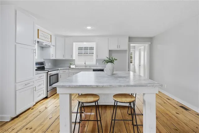 a kitchen with white cabinets and appliances