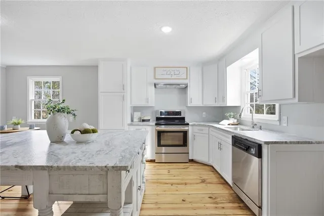 a kitchen with stainless steel appliances granite countertop sink stove and cabinets