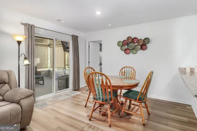 a dining room with furniture a chandelier and wooden floor