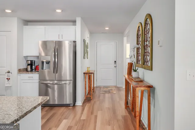 a kitchen with stainless steel appliances granite countertop a refrigerator and a stove top oven