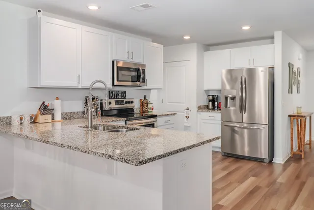a kitchen with a refrigerator a microwave a sink and cabinets