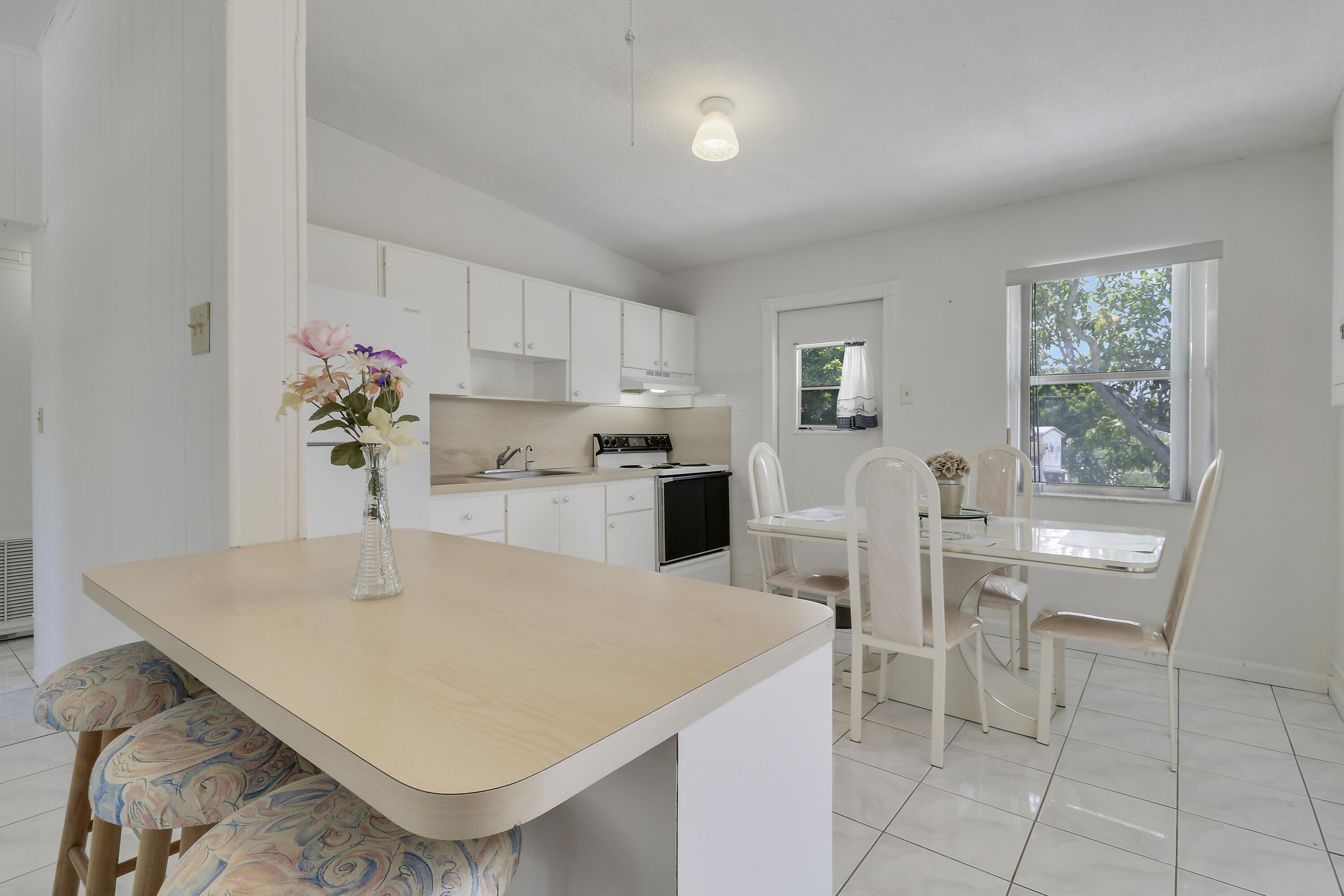 5519 Columbus Road West Palm Beach, FL 33405 - Photo 4 of 22 a kitchen with a white cabinets and chairs