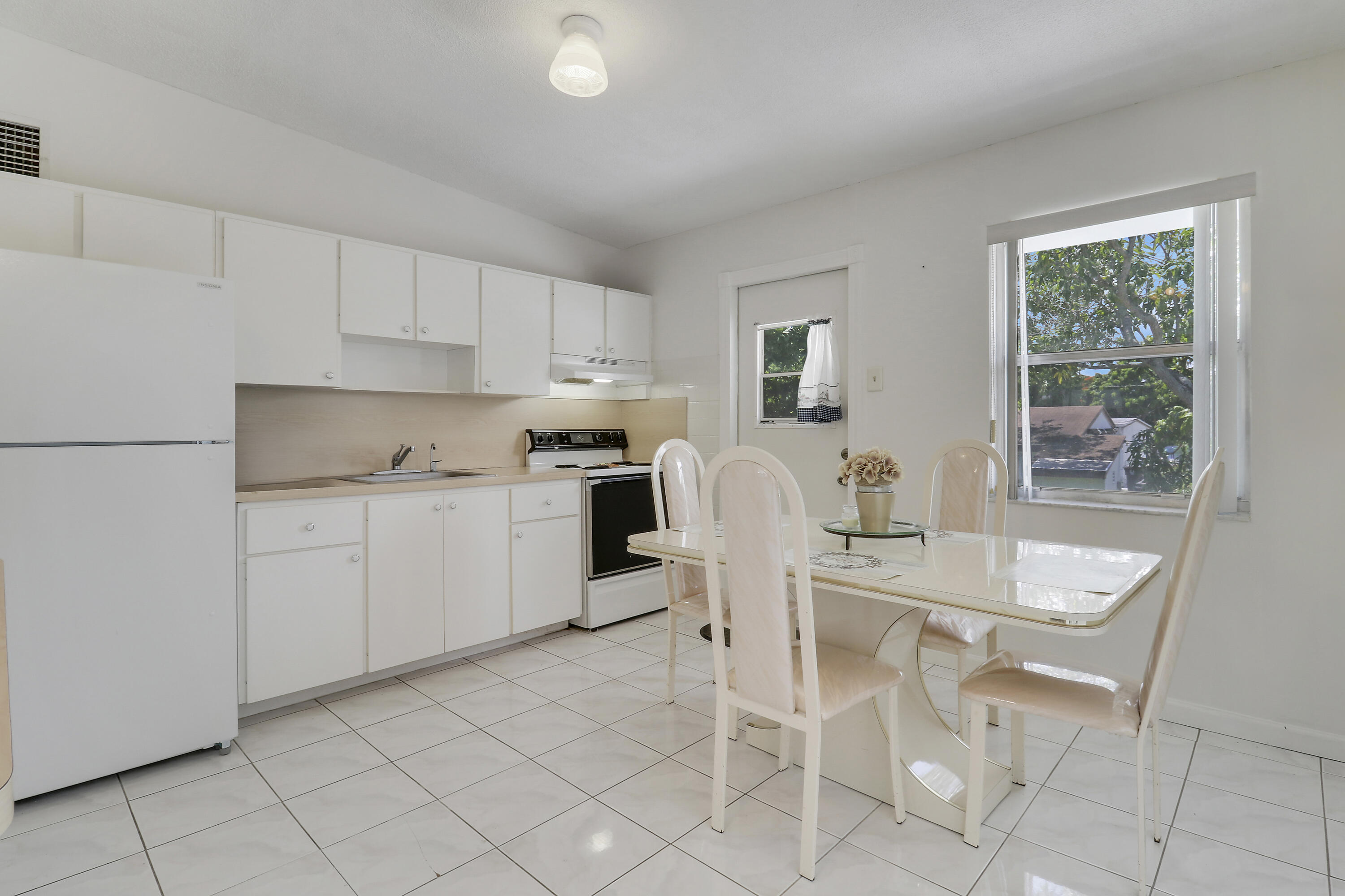 5519 Columbus Road West Palm Beach, FL 33405 - Photo 5 of 22 a kitchen with a dining table chairs and cabinets