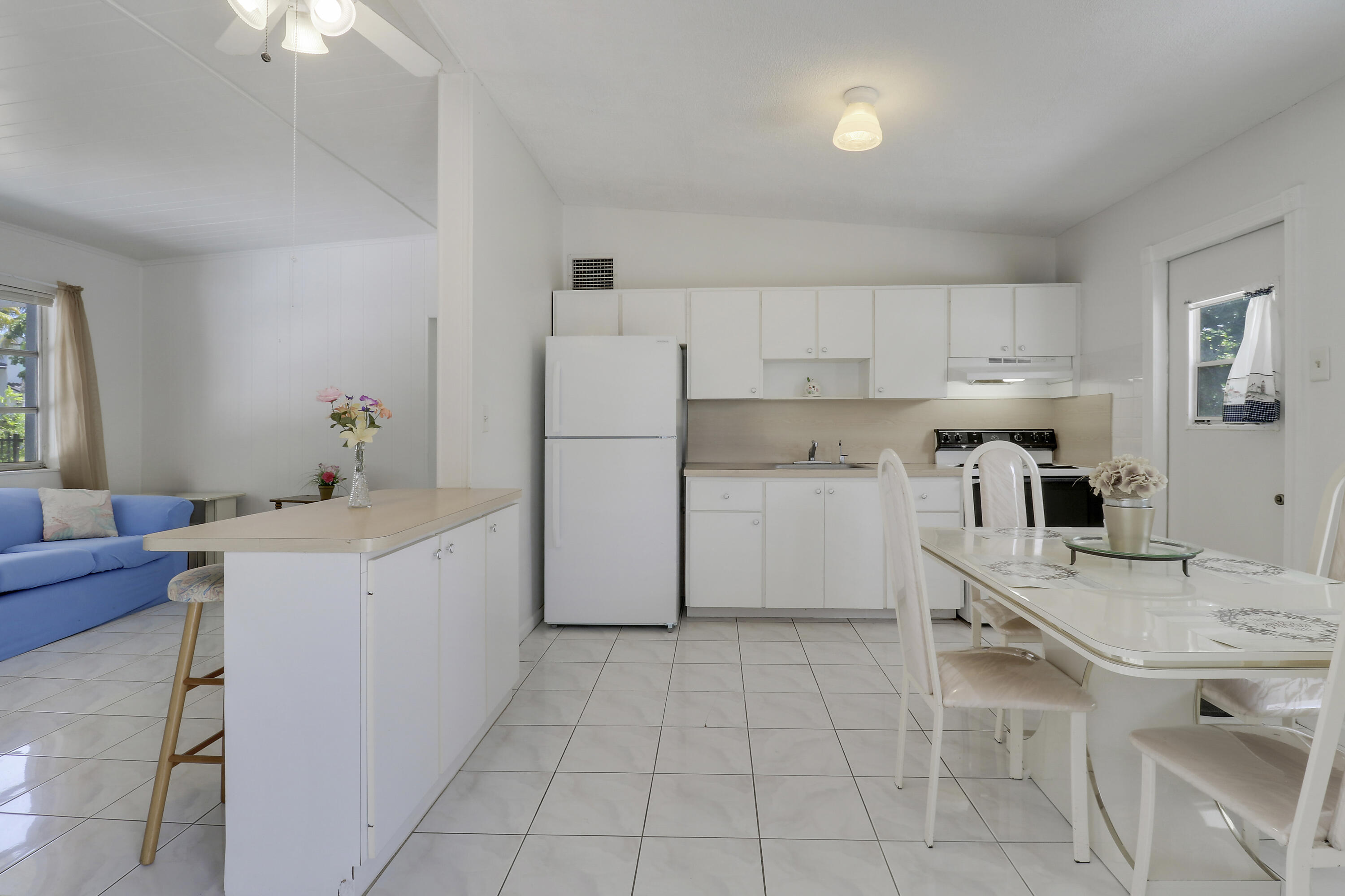 5519 Columbus Road West Palm Beach, FL 33405 - Photo 6 of 22 a kitchen with a sink a stove a refrigerator and white cabinets