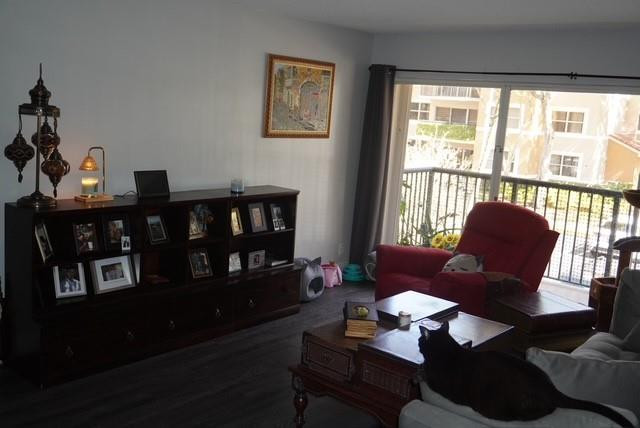 8871 Wiles Road, Unit 201 Coral Springs, FL 33067 - Photo 17 of 70 a living room with furniture wooden floor and a floor to ceiling window
