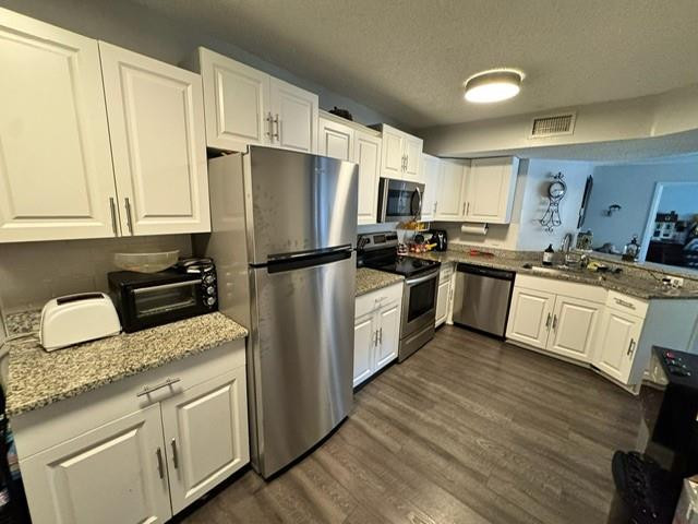 8871 Wiles Road, Unit 201 Coral Springs, FL 33067 - Photo 24 of 70 a kitchen with cabinets stainless steel appliances and wooden floor