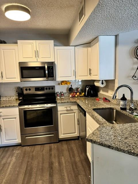 8871 Wiles Road, Unit 201 Coral Springs, FL 33067 - Photo 28 of 70 a kitchen with granite countertop a stove a sink and a microwave