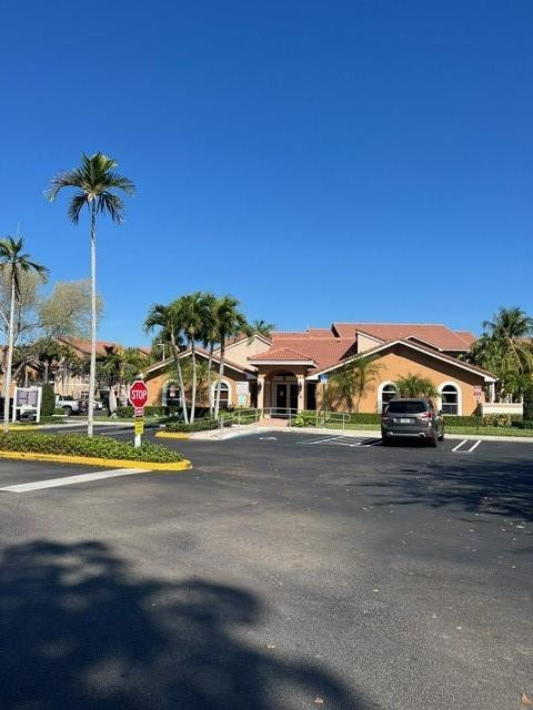 8871 Wiles Road, Unit 201 Coral Springs, FL 33067 - Photo 4 of 70 a front view of house with yard and car parked