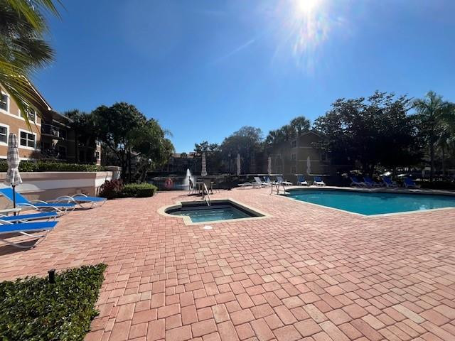 8871 Wiles Road, Unit 201 Coral Springs, FL 33067 - Photo 6 of 70 a view of swimming pool with seating space and trees in the background