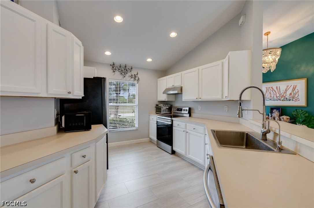 3801 28th Street Southwest Lehigh Acres, FL 33976 - Photo 11 of 37 a kitchen with kitchen island granite countertop a sink stainless steel appliances and cabinets