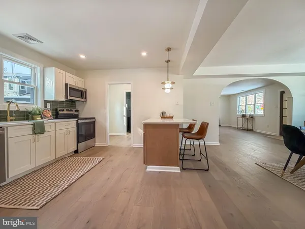 a kitchen with a table chairs refrigerator and microwave
