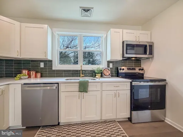 a kitchen with stainless steel appliances a stove a sink and a microwave