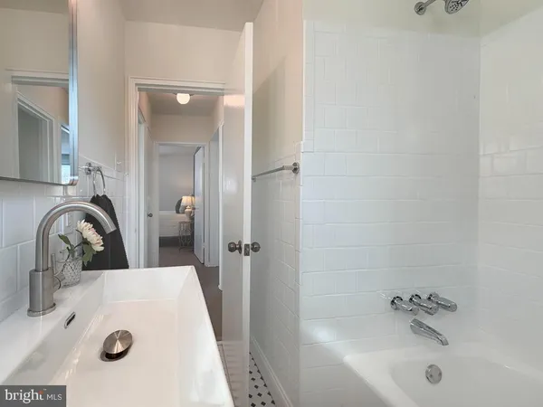 a bathroom with a tub sink a mirror and shower