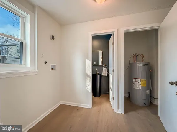 a view of an empty room with bathroom and a window