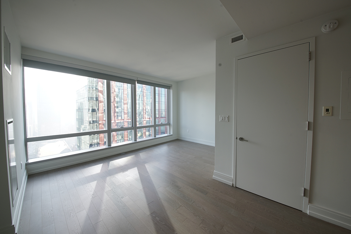 555 10th Avenue, Unit 41M Manhattan, NY 10018 - Photo 2 of 20 a view of empty room with wooden floor and fan