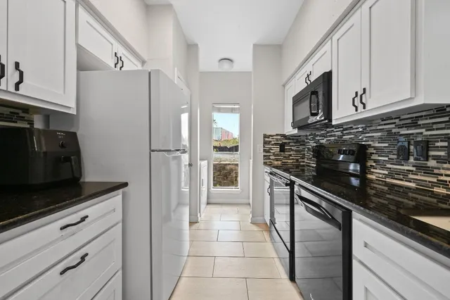 a kitchen with stainless steel appliances granite countertop a refrigerator and a stove top oven