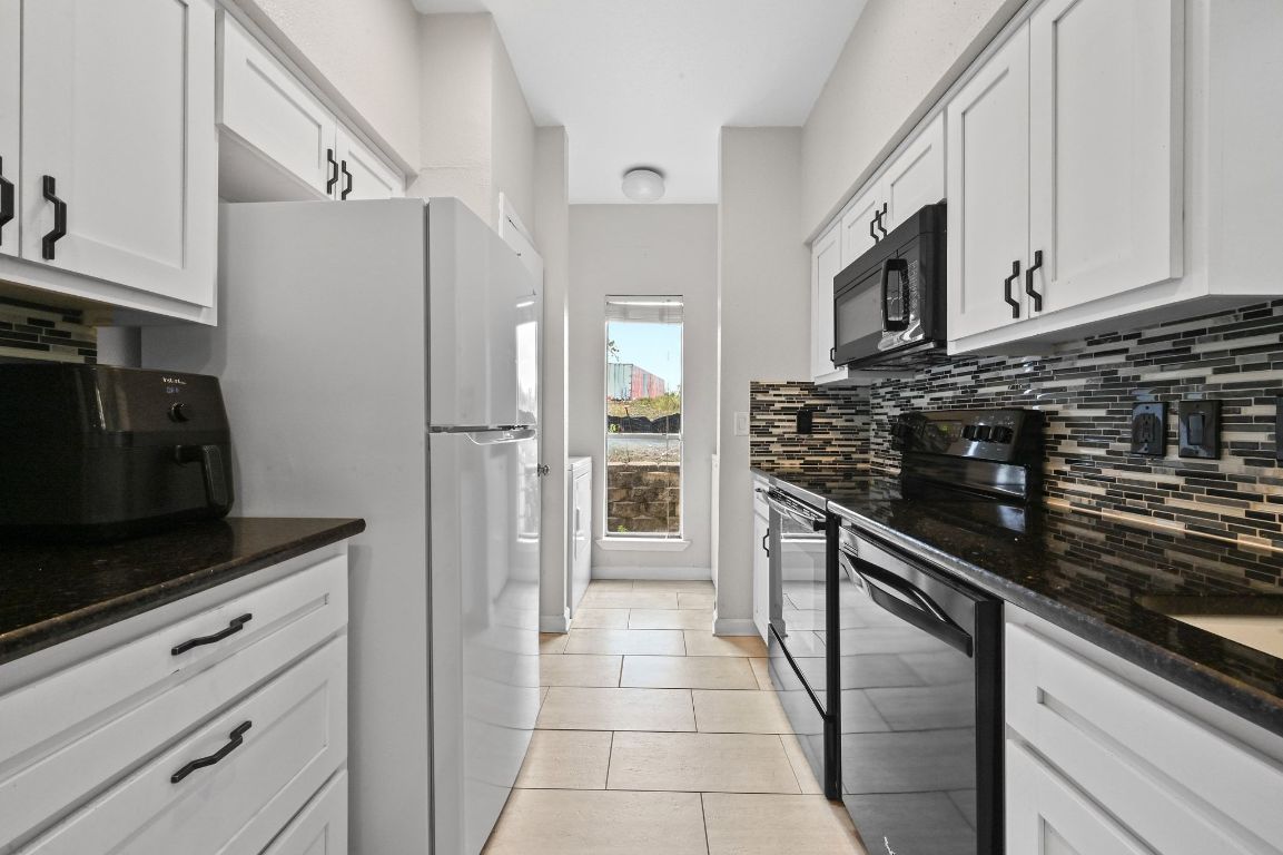 a kitchen with stainless steel appliances granite countertop a refrigerator and a stove top oven