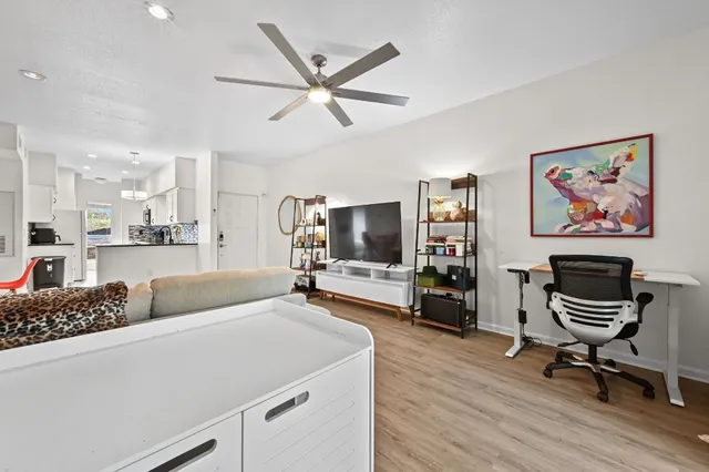 a living room with furniture and a flat screen tv with wooden floor