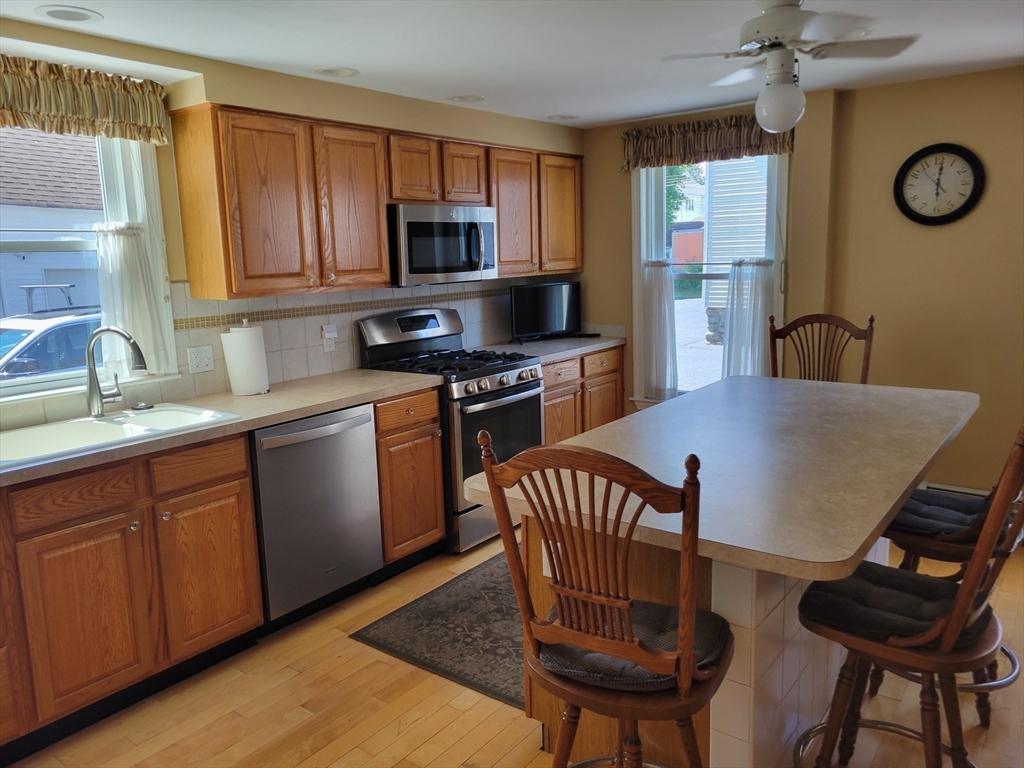 40 June Street Worcester, MA 01602 - Photo 19 of 28 a kitchen with stainless steel appliances granite countertop a kitchen island hardwood floor sink and cabinets