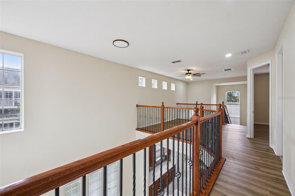 551 Terrace Spring Drive Orlando, FL 32828 - Photo 18 of 41 a view of a hallway with wooden floor and stairs