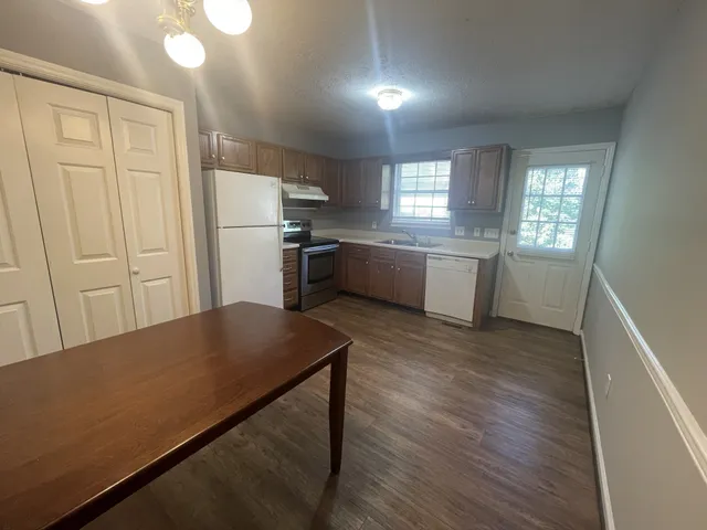 a kitchen with refrigerator cabinets and wooden floor