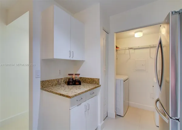 a kitchen with a granite countertop sink and refrigerator