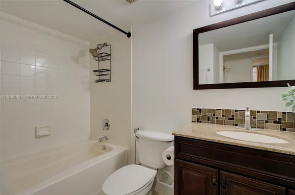 a bathroom with a bathtub sink mirror and toilet