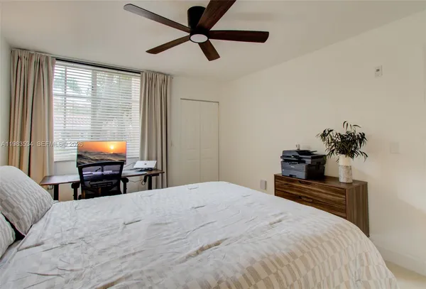 a bedroom with a bed and painting on the wall