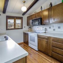 361 Lagoon Lane Silverthorne, CO 80498 - Photo 4 of 24 a kitchen with stainless steel appliances a sink dishwasher a stove microwave and a refrigerator with wooden floor