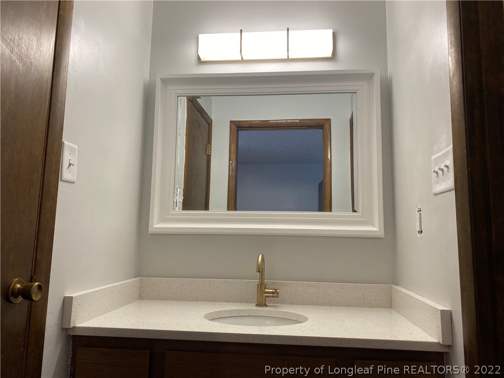 1750 Rim Road Fayetteville, NC 28314 - Photo 19 of 22 a bathroom with a sink and a mirror