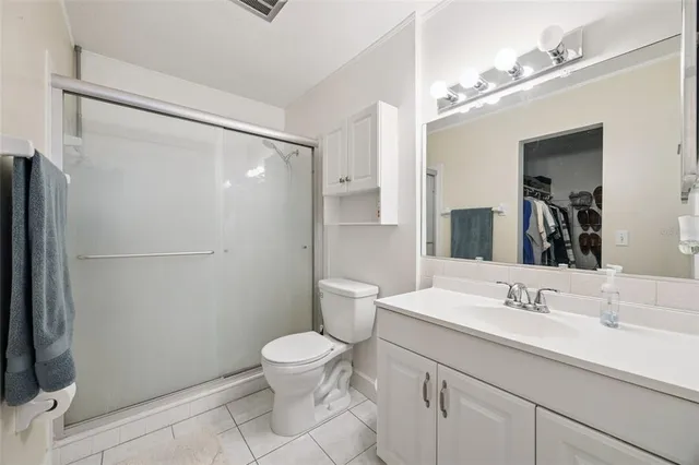 a bathroom with a shower sink vanity mirror and toilet
