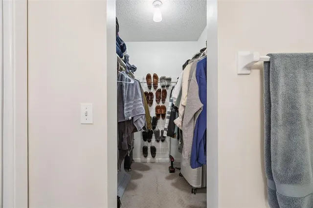 a view of walk in closet with clothes