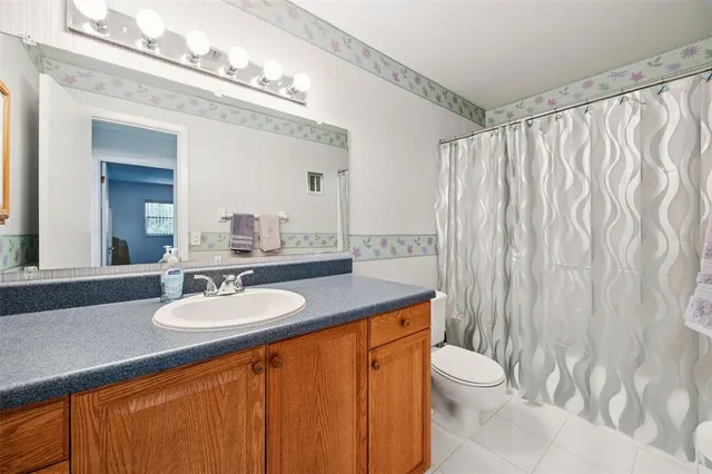 a bathroom with a granite countertop sink a toilet and a mirror