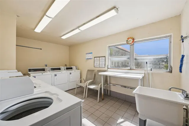 a room with a sink a washer and dryer