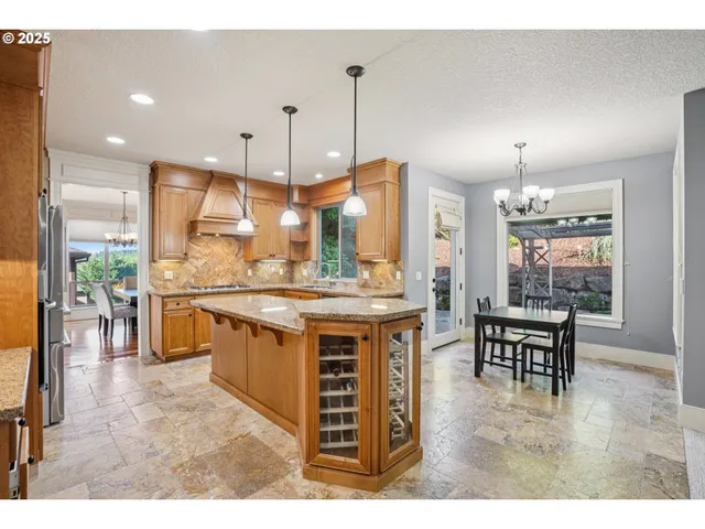 a kitchen with kitchen island a counter top space a sink stainless steel appliances and cabinets