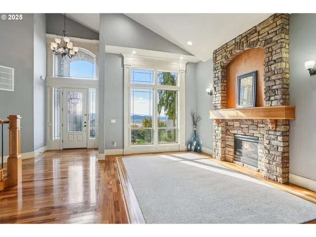 a view of an empty room with a fireplace and windows