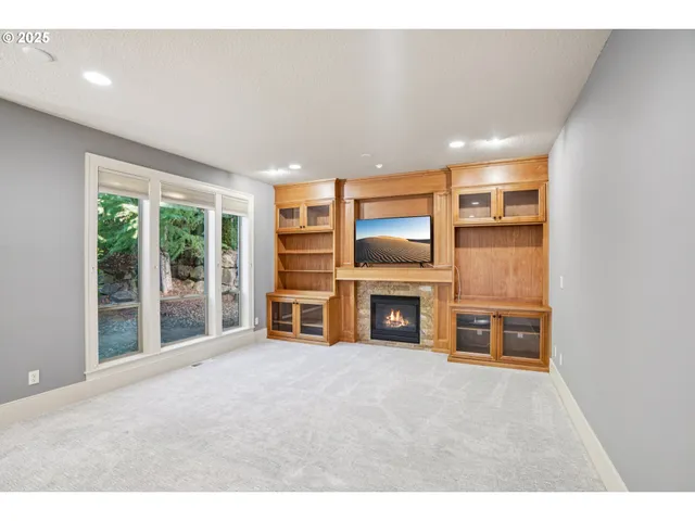 a living room with furniture a flat screen tv and floor to ceiling window